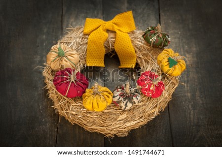 Autumn wreath on a straw base from handmade textile pumpkins. DIY