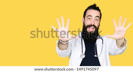 Doctor with long hair wearing medical coat and stethoscope showing and pointing up with fingers number ten while smiling confident and happy.