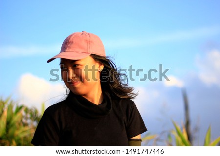 A girl wearing a hat, smiling.