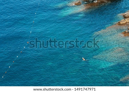 Aerial view of the Mediterranean Sea with a person who snorkels in the Vernazza village, Cinque Terre National Park, UNESCO world heritage site. La Spezia, Liguria, Italy, Europe