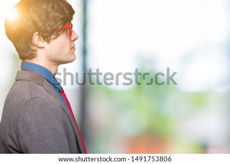 Young handsome business man wearing red glasses over isolated background looking to side, relax profile pose with natural face with confident smile.