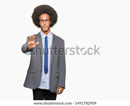 Young african american business man with afro hair wearing glasses doing stop sing with palm of the hand. Warning expression with negative and serious gesture on the face.