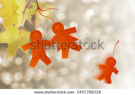 
Child loss concept. Silhouettes of people cutout of leaf. Family in the form of autumn leaves