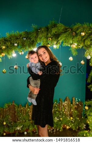 Young mother with a child near New Year decorations. Young Happy Mother With Baby
