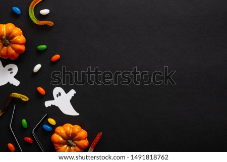Halloween frame with pumpkins, ghosts, candy on black background. Halloween party invitation card mockup. Flat lay, top view, copy space.