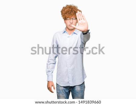 Young handsome business man with afro wearing glasses doing stop sing with palm of the hand. Warning expression with negative and serious gesture on the face.