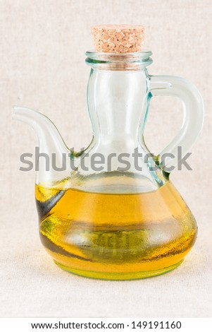 Olive oil in jar on warm background