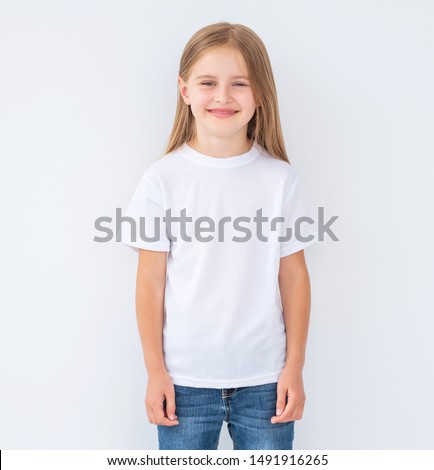 Funny little kid girl wearing a blank white t-shirt, isolated on white background