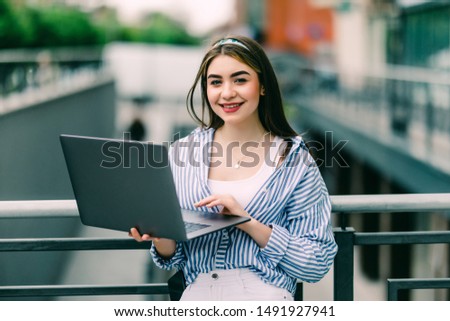 young girl with a laptop on the streets of the city