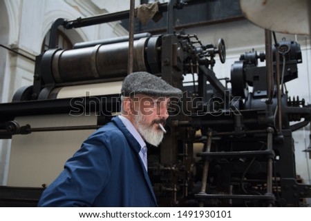 Man with beard working on printing press
