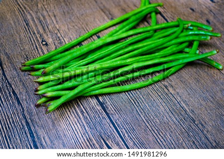 A bunch of raw cowpeas, on wooden background, with copy space. Cowpea is a rich source of vegetable proteins, vitamins, calcium, antioxidant and fiber.
