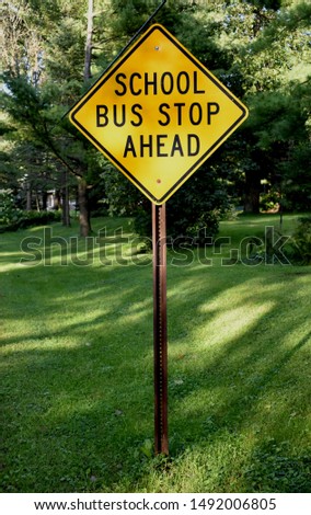 A school bus stop ahead sign warns people of a bus stop location