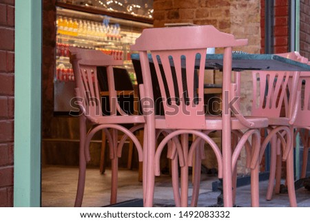 The chairs in the foreground are designed for blurred cafe view logo in the background.
