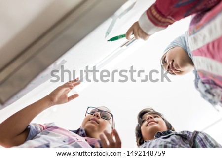 Teenage students discussing on board in classroom