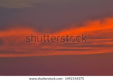 Smoky sunset clouds streaked with orange 
