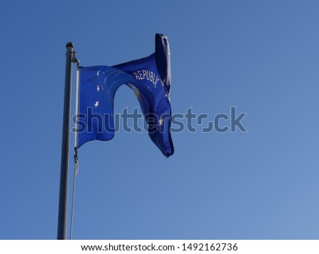Unfurled flag of Key West, Florida, furled and flying out in the wind from a pole  