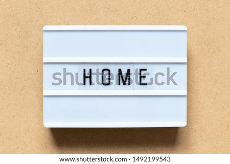 White lightbox with word home on wood background
