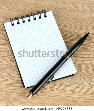 Notebook and pen on wooden table