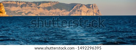 Seascape Water, Mountains and Yacht in the evening. Summer Season, August. Web Banner. Natural Background.