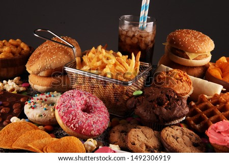 Unhealthy products. food bad for figure, skin, heart and teeth. Assortment of fast carbohydrates food with fries and cola Royalty-Free Stock Photo #1492306919