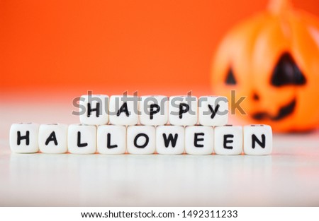 Halloween background orange with word blocks happy halloween decorations and pumpkin jack o lantern funny spooky on white wooden table happy holiday concept 