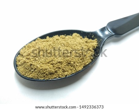 A picture of coriander powder on black spoon
