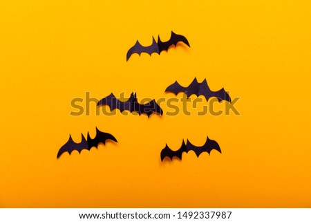 Crafts for the concept celebration of Halloween. Figures of a black bat, cut from black paper on yellow background. Place for text Mock up Top view