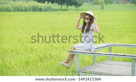  Women sit on wood chairs  in green rice field .happy and travel concept                               