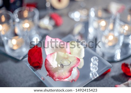 Golden ring on a rose petal. An offer of marriage. Close-up.