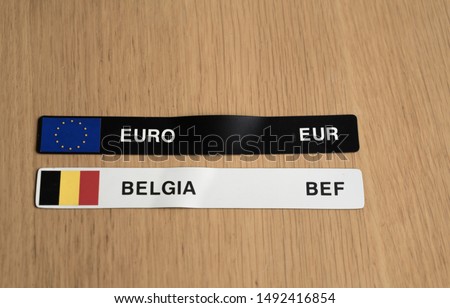 Two magnetic stripes with EUR and BEF currency symbols. (Translation: Belgium). Black label for Euro and white one for Belgian currency Franc (valid from 1832 until 2002). Belgian national colors.
