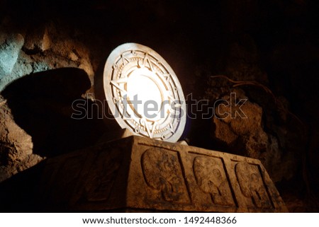 Circular antique mirror made of brass in rock cave.