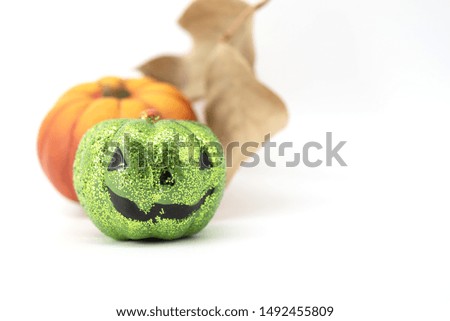 Halloween composition- Green pumpkin with orange pumpkin and autumn leaves in background with copy space
