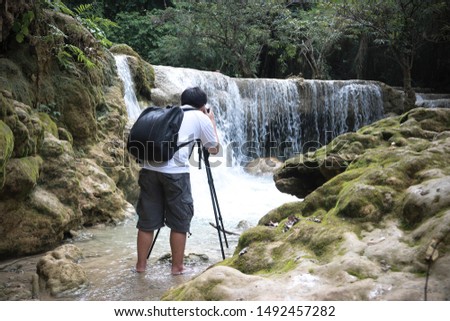The photographer is taking pictures of the waterfall.