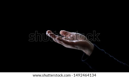 Male hand asking for help on dark background, begging for donation, poverty