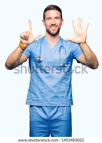 Handsome doctor man wearing medical uniform over isolated background showing and pointing up with fingers number seven while smiling confident and happy.