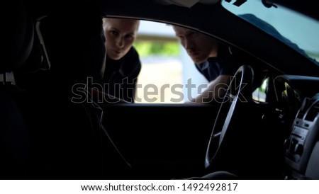 Police officers talking with driver in car, searching for wanted criminal, check Royalty-Free Stock Photo #1492492817