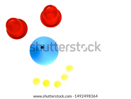Humorous caricature of doctor face made of blue medical enema, red massage cups and antiseptic yellow tablets on white background. Medical humor. Flat lay of sketchy funny face with a smile