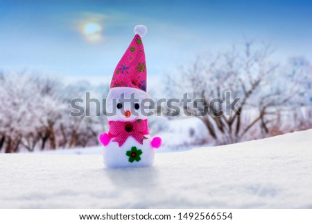Lone snowman on winter landscape background during sunset