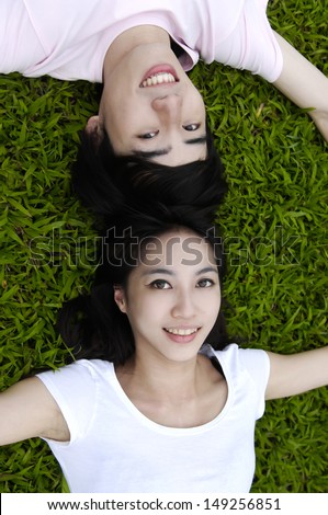 Young happy asian couple laying on grass