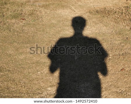 Shadow of people on dry grass