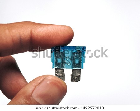 Hand holding fuse of motorcycle isolated on white background. Electric and automotive maintenance