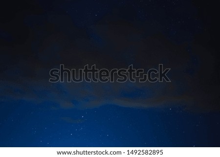 blue starry sky through gray clouds