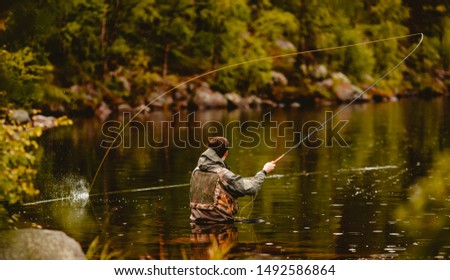 Fisherman using rod fly fishing in mountain river. Royalty-Free Stock Photo #1492586864