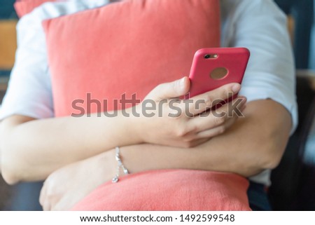 Asian women using moblie phone in a coffee shop