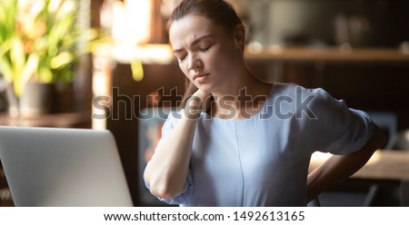 Stressed upset business woman feeling backpain working on laptop sitting in incorrect posture, tired fatigued student rub back suffer from spine muscular pain injury lumbar backache concept in office Royalty-Free Stock Photo #1492613165