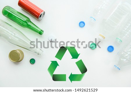 Recycle sign and plastic bottle on white background. Close up aluminum can and glass bottle on isolated backdrop in green concept, reduce waste and reuse materials.