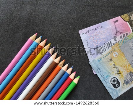 Australian money and color pencils on the black background 