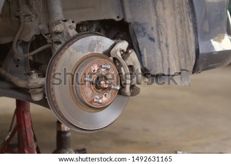 Car brake part at garage,car brake disc without wheels.Suspension of car in car service. Close up.                        