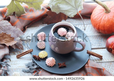 Cup of coffee, meringues, pumpkins, leaves, plaid on a window background, home comfort concept, Thanksgiving, autumn season