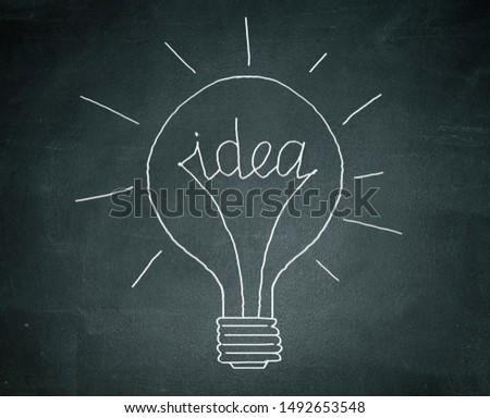 There is a chalk drawn light bulb with a word "idea" instead of a spiral on a blackboard.